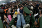 2008年1月31日，广州火车站。一位晕倒的旅客被一个个接力从等待进站的人群中抬出，武警随后将她抬至临时急救中心救助。
